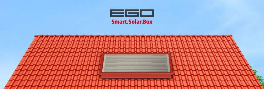 Red tiled rooftop with a grey rectangular skylight under a clear blue sky; centered logo reads 'EGO Smart.Solar.Box'.
